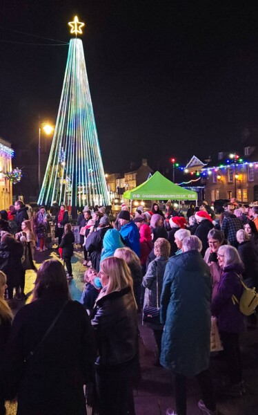 Carol singing in Melksham Market Place around the Christmas tree