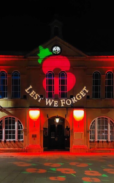 Town Hall with remembrance day projection of poppies projected on the front and pavement.