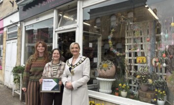 Mayor Saffi Rabey hands over a certificate to the winners of the Spring window competition.
