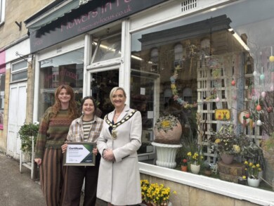 Mayor Saffi Rabey hands over a certificate to the winners of the Spring window competition.