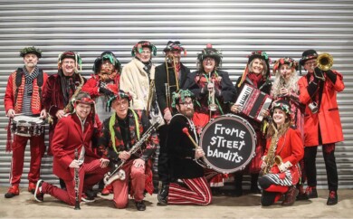 A big brass band in front of a metal shutter