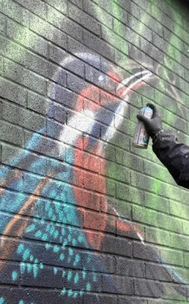 Mr Sce spray painting the new kingfisher mural