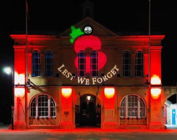 Town Hall with remembrance day projection of poppies projected on the front and pavement.